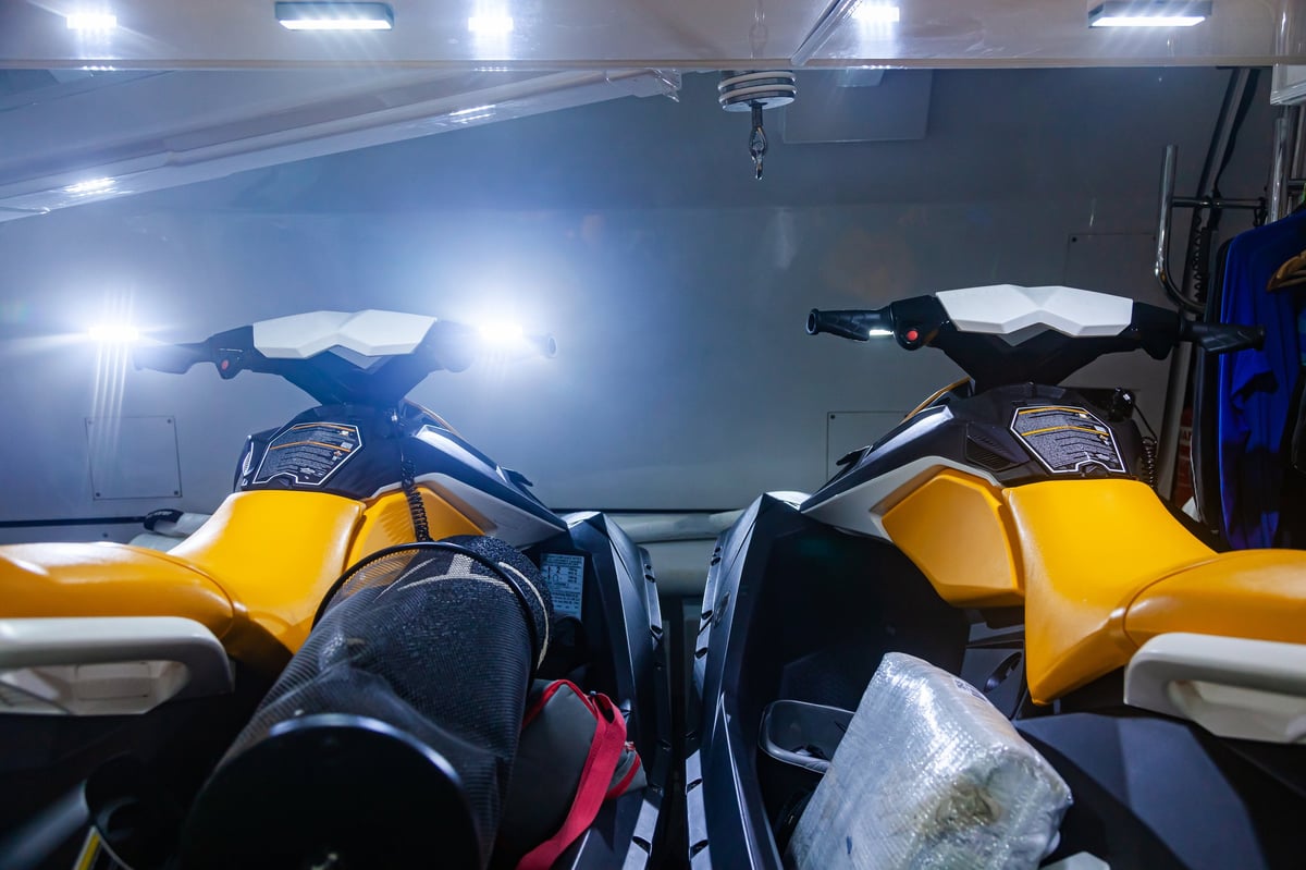 Two jet skis docked in a waterfront garage